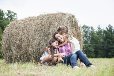 Mother playing outdoors with her daughters. - MINF01307