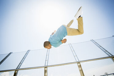 Young man somersaulting on a bridge. - MINF01367