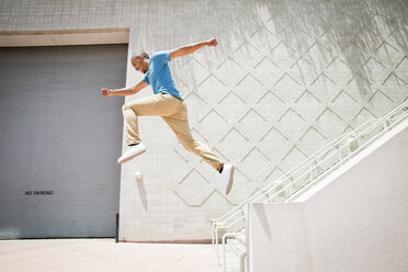 Young man jumping in the air down a stairway. - MINF01377