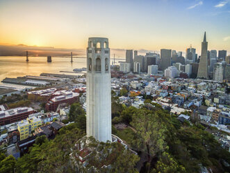 Der Coit Tower, ein Art-Déco-Denkmal im Stadtteil Telegraph Hill in San Francisco. Luftaufnahme bei Sonnenuntergang über der Stadt San Francisco. - MINF01436