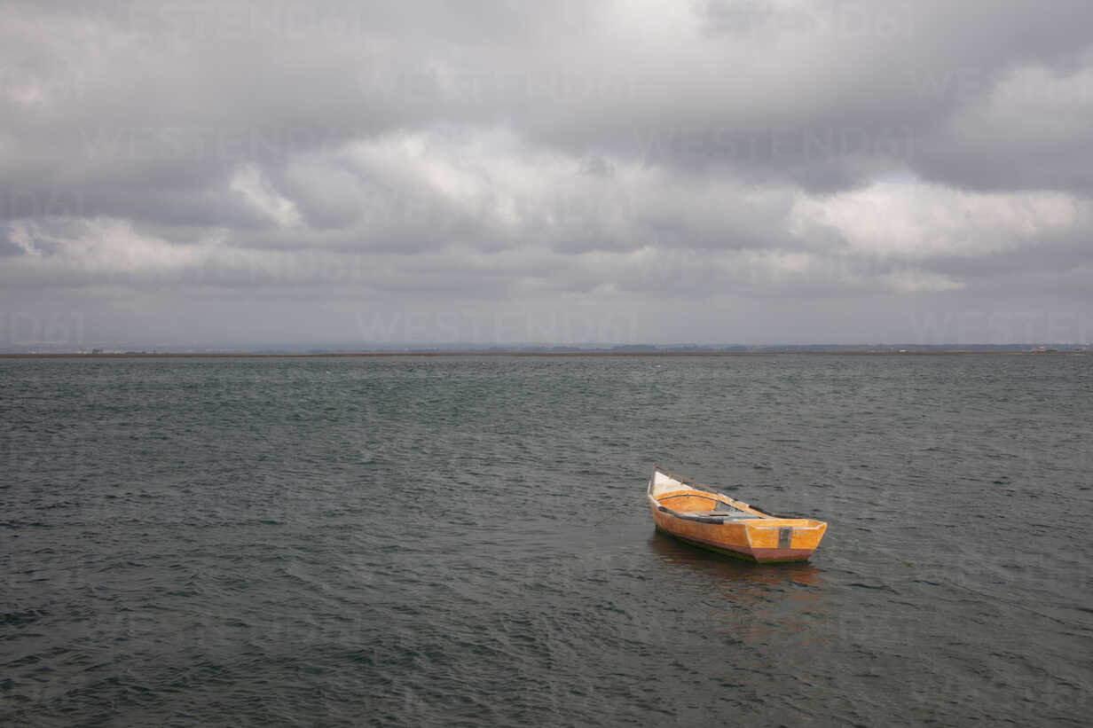A small wooden boat moored in open water, off the Portuguese coast. stock  photo