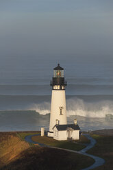 The historic Yaquina Head tower lighthouse on a headland overlooking the Pacific coastline. - MINF01475