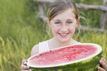 Ein Kind hält eine halbe frische Wassermelone. - MINF01498