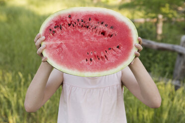 Ein Kind hält eine halbe frische Wassermelone. - MINF01499