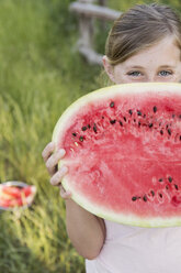 Ein Kind hält eine halbe frische Wassermelone. - MINF01500