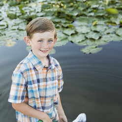 Ein kleiner Junge steht mit einem Fischernetz im flachen Wasser. - MINF01521