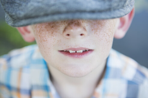 A young boy with a freckled nose, wearing a cap with a large brim. - MINF01529