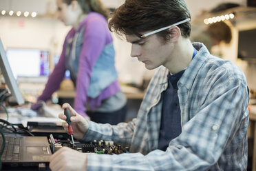 Zwei Personen in einer Computerwerkstatt: Techniker, junge Leute, die Computer reparieren. - MINF01580