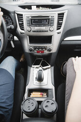 Road trip. Two women sitting in a car, coffee cups on the console between the seats. - MINF01687