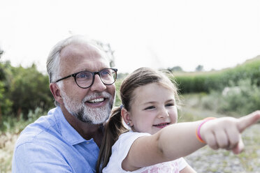 Happy father and daughter having fun, girl pointing - UUF14577