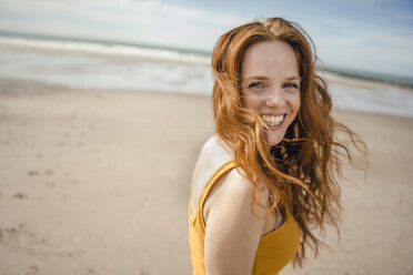 Porträt einer rothaarigen Frau, die fröhlich am Strand lacht - KNSF04212