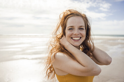 Portrait of a redheaded woman, laughing happily on the beach - KNSF04218
