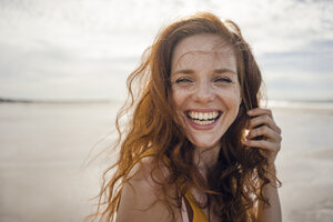 Portrait of a redheaded woman, laughing happily on the beach - KNSF04220