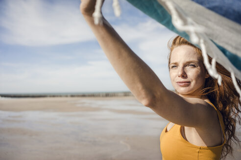 Woman at the beach, holding swaying towel - KNSF04224
