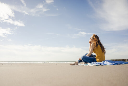 Woman sitting on the beach, enjoying the sun - KNSF04226