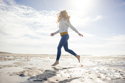 Happy woman having fun at the beach, running at the sea - KNSF04236