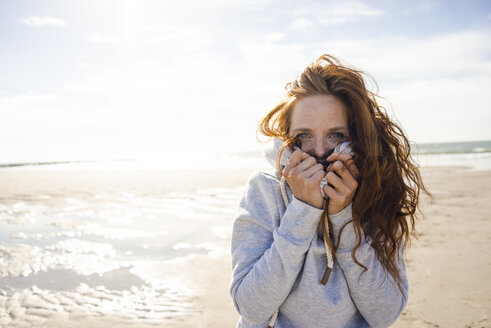 Redheaded woman enjoying fresh air at the beach - KNSF04241