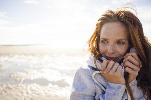 Rothaarige Frau genießt die frische Luft am Strand, lizenzfreies Stockfoto