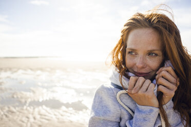 Rothaarige Frau genießt die frische Luft am Strand - KNSF04242