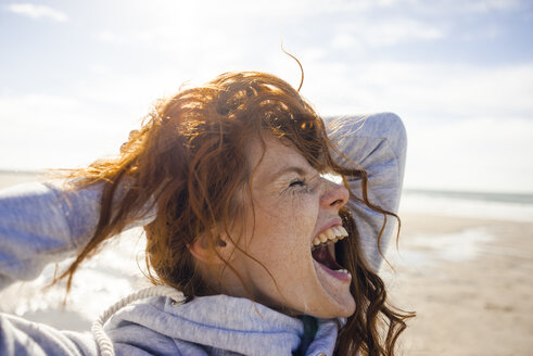 Redheaded woman enjoying fresh air at the beach - KNSF04243