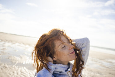 Redheaded woman enjoying fresh air at the beach - KNSF04244