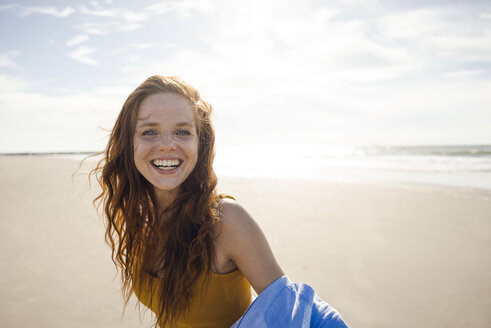 Porträt einer rothaarigen Frau, die fröhlich am Strand lacht - KNSF04248