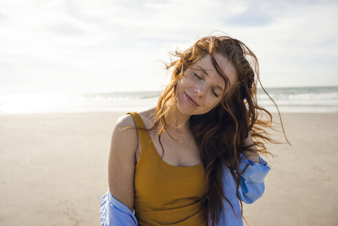 Portrait of a redheaded woman on the beach, with eyes closed - KNSF04249