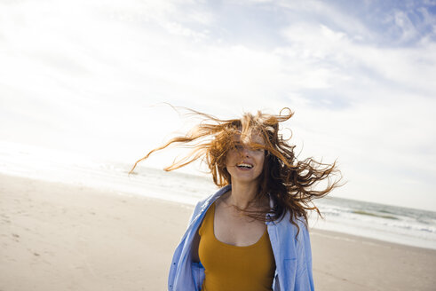 Portrait of a redheaded woman, laughing happily on the beach - KNSF04251