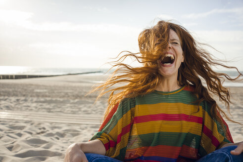 Woman sitting on the beach, screaming for joy - KNSF04260