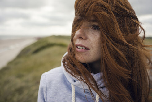 Redheaded woman enjoying fresh air at the beach - KNSF04282