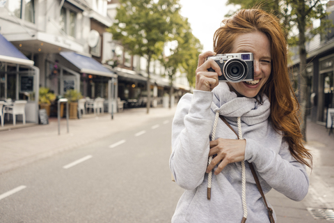 Rothaarige Frau mit Analogkamera, lizenzfreies Stockfoto