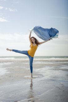 Happy woman having fun at the beach, dancing and swaying towel - KNSF04313