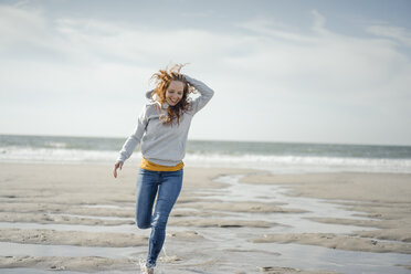 Happy woman having fun at the beach, running at the sea - KNSF04317