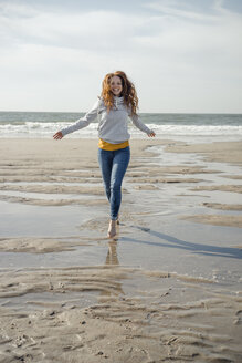 Happy woman having fun at the beach, running at the sea - KNSF04318