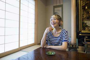 A woman sitting at a table. - MINF01740