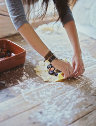 A domestic kitchen. A woman creating an open pastry tart with vegetables. - MINF01858