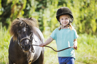 Ein Mädchen und ein Pony auf einem Feld. - MINF01927