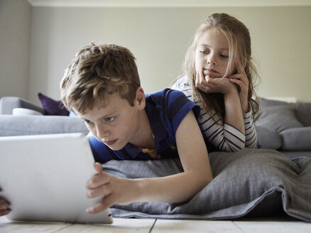 Ein Junge und seine Schwester schauen auf ein digitales Tablet. - MINF02001