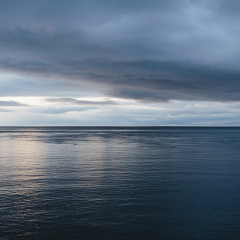 Das Meer und der Himmel über dem Puget Sound in Washington, USA. Der Horizont mit leichten Wolkenschichten darüber., lizenzfreies Stockfoto