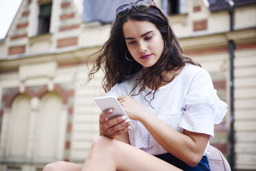 Portrait of young woman using cell phone outdoors - ABIF00755