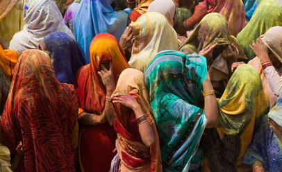 A colourful crowd of people celebrate the Holi Festival, Mathura, Uttar Pradesh, India - MINF02138