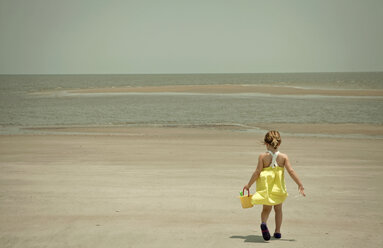 Mädchen trägt Schaufel und Eimer am Strand - ISF17023