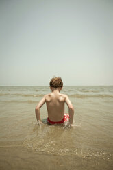 Boy playing in waves on beach - ISF17025