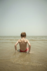 Junge spielt in den Wellen am Strand - ISF17025