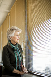 Senior woman looking through window - ISF17085