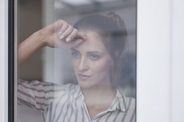 Einsame Frau schaut aus dem Fenster - JOSF02316