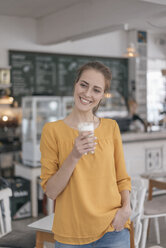 Young business owner standing in her coffee shop, drinking coffee - JOSF02326