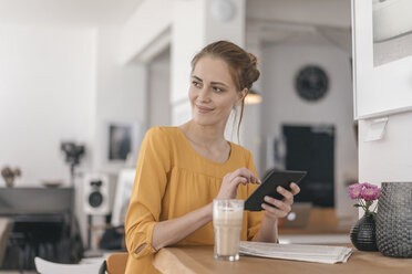 Junge Frau arbeitet in einem Coworking Space und benutzt ein digitales Tablet - JOSF02329