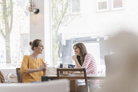 Zwei Freundinnen treffen sich in einem Café und reden, lizenzfreies Stockfoto