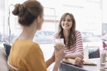 Two girlfriends meeting in a coffee shop, talking - JOSF02334